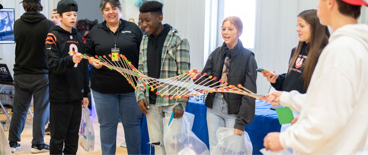 An instructor and students waving a large candy wave model.