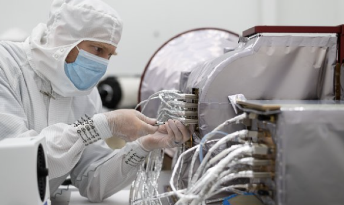 A member of the AWE mission team dressed in a cleanroom coverall, working on the AMTM instrument.