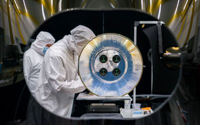 SDL engineers work on the AWE telescope in a cleanroom at SDL facilities on USU's Innovation Campus in North Logan. AWE's four telescopes and aperture baffle are shown in this image.