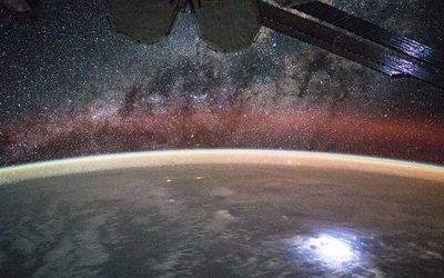 Image taken from the International Space Station showing orange swaths of airglow above Earth's atmosphere.
