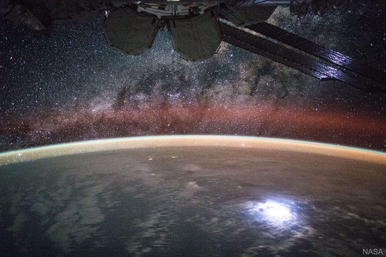 An image taken from the International Space Station shows orange swaths of airglow hovering in Earth’s atmosphere.