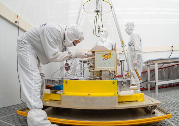 Mission team members working on the AMTM instrument in a cleanroom. 