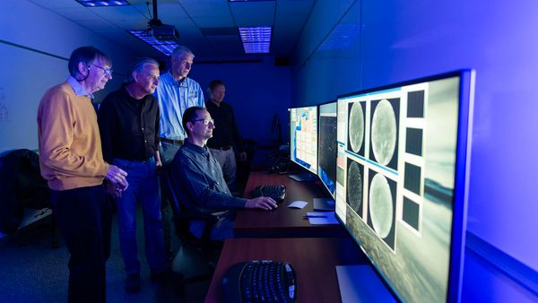 AWE Emeritus Principal Investigator Michael Taylor and Principal Investigator Ludger Scherliess of USU’s College of Science, along with Project Manager Burt Lamborn, Ground Systems & Mission Operations Manager Pedro Sevilla, and Systems Engineer Harri Latvakoski from SDL, observe some the first live images from the AWE instrument being transmitted from the ISS to AWE’s Mission Operations Center at SDL. (Photo Credit: SDL/Allison Bills)