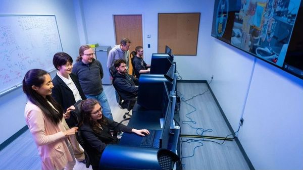 Members of the AWE science team gather in the mission control room at Utah State University to view data collected by the mapping instrument mounted on the outside of the International Space Station. Credit: SDL/Allison Bills