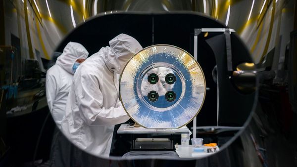 SDL Electro-Optical Engineer Kendra Schuettpelz is shown here with AWE in SDL's stray light test facility. AWE’s four telescopes and aperture baffle can be seen in this image. (Photo Credit: SDL/Allison Bills)