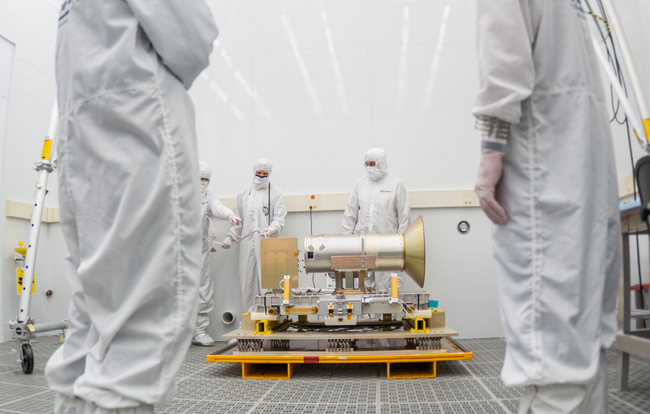 Mission team members working on the AMTM instrument in a cleanroom.