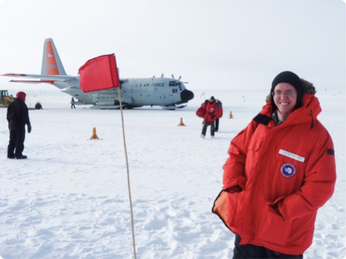 Researchers and a cargo plane preparing to leave the snow-covered South Pole after instrument servicing.
